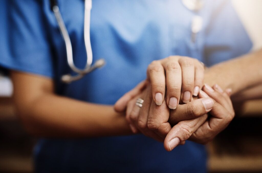 Nahaufnahme, Arzt hält Hände mit älteren Frau und Krebs Pflege oder Unterstützung. Gesundheitspflege oder Vertrauen, Empathie oder Mitgefühl und weibliche Betreuerin oder Krankenschwester, die die Hand einer älteren Person hält, um Hoffnung und Freundlichkeit zu vermitteln