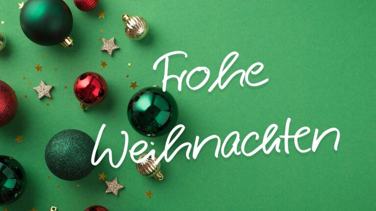 Grüne Weihnachtskugeln und goldene Sterne mit Schriftzug